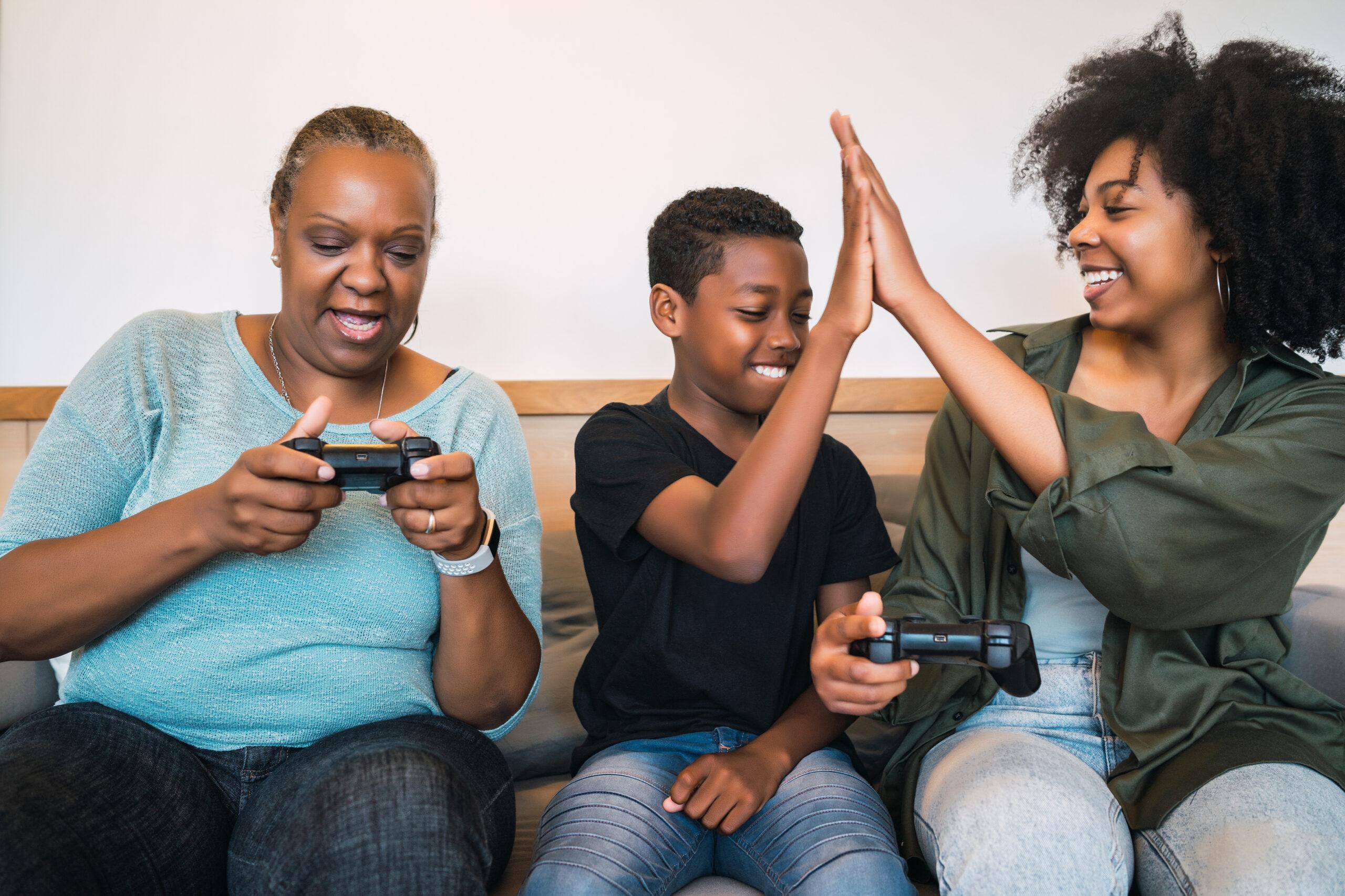Grandmother, mother and son playing video games at home. Videogames: Uma Diversão Intergeracional com Benefícios para Todas as Idades